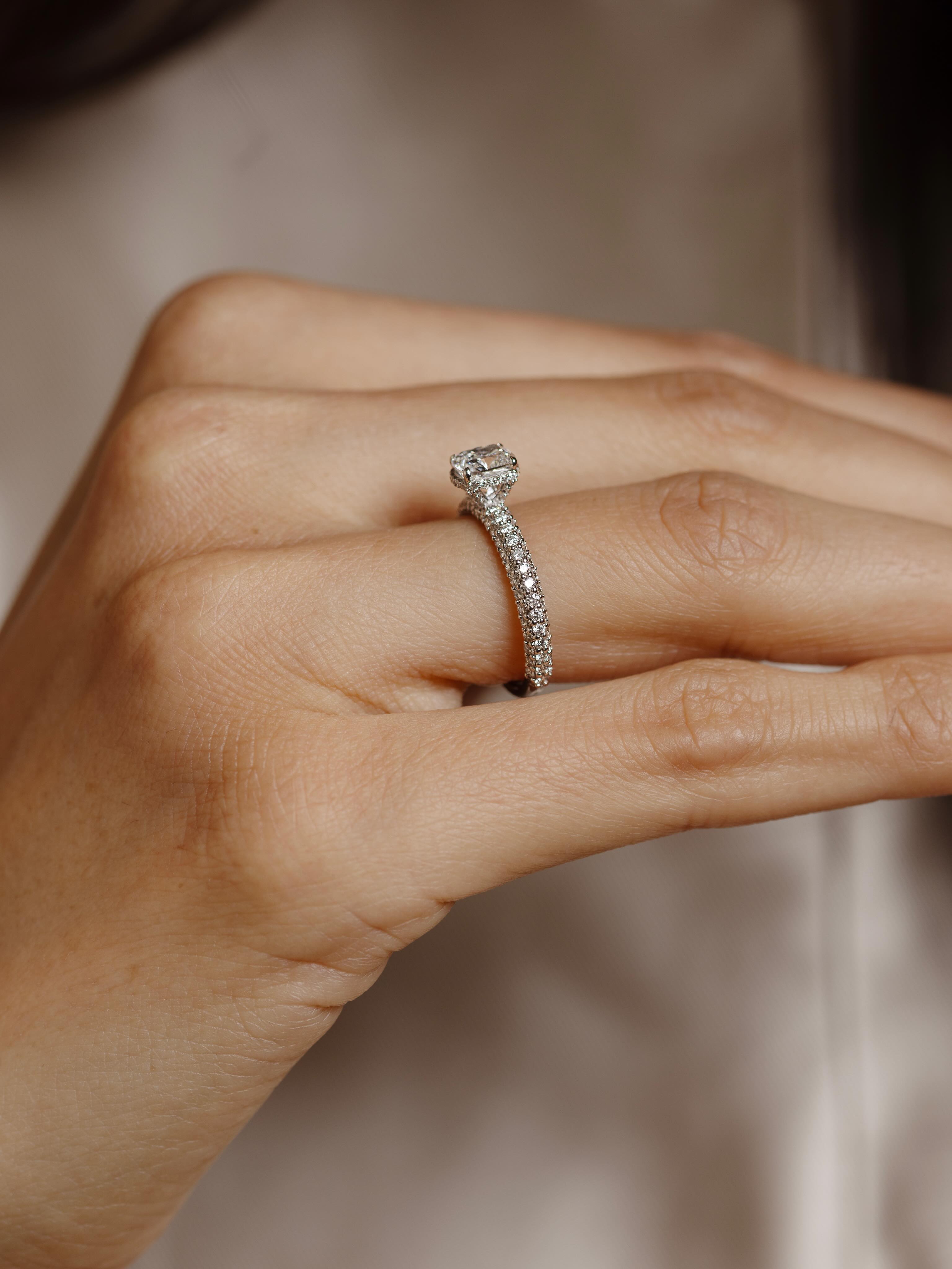 Cuscino II Diamantring 1,95 carat er en spektakulær diamantring som kombinerer tidløs eleganse med strålende briljans. Den perfekt slipte, GIA-sertifiserte midtstenen på 1,01 carat står i sentrum og fremheves av glitrende sidediamanter på totalt 0,94 carat💎